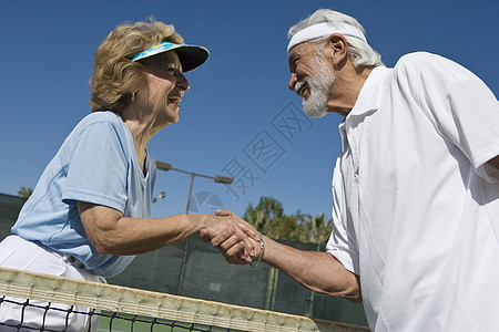 老夫妇在网球场上握握手 把网头交给了老夫妻图片
