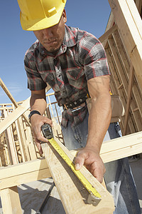 测量木材的建筑工人的低角度视角图图片