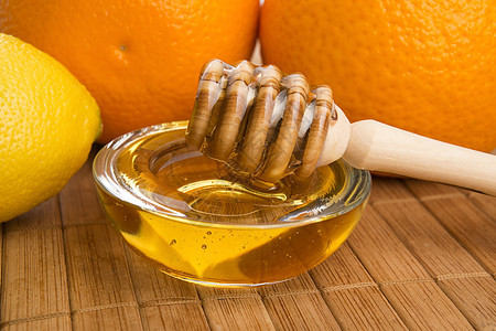 含柠檬和橙子水果的新鲜蜂蜜液体勺子漏勺餐具黄色玻璃生活方式早餐甜食美食家图片