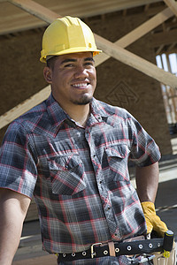 一位在建筑工地身着硬头巾的快乐男建筑师肖像图片