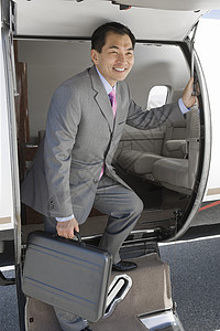 快乐的日本商务人士在机场从私人飞机上坠落下来图片