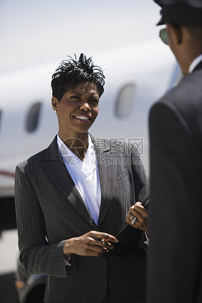 一名非裔美国商业女商务人士与机场司机沟通;在机场工作图片