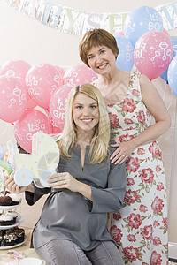 快乐的年长妇女的肖像 在婴儿淋浴时有怀孕女儿女士母亲摇篮气球成人玩具运输装潢友谊派对图片
