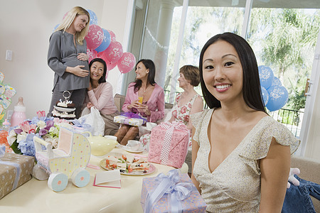 参加婴儿淋浴的妇女女士饮食种族桌子微笑怀孕肚子成人活动前景图片