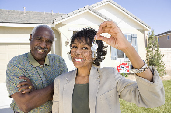 在新房子前配有钥匙的 非裔美裔幸福情侣的肖像图片