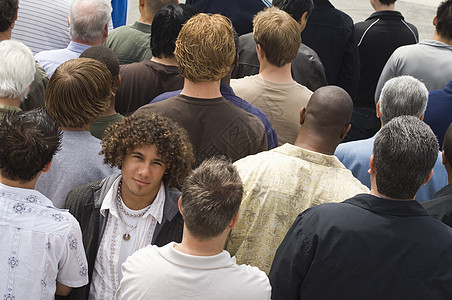 青年男子站在人群中背景图片