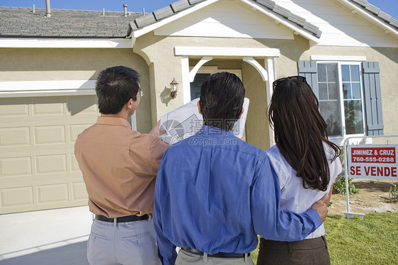 与房地产经纪人对房价计划进行解释的一对夫妇观点图片