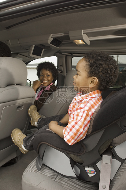 一名非洲裔美国妇女与小男孩坐在车内前方的肖像图片