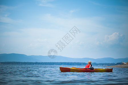 女人在Kayak上放松和享受生活背心救生衣蓝色金发安全旅游女孩乐趣夹克航行图片