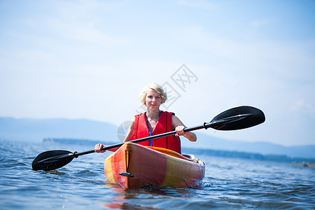 妇女与安全独自一人在一片平静的海面上乐趣活动女士背心女性旅行生活独木舟橙子运动图片