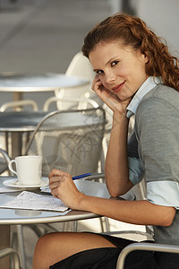 坐在户外咖啡厅的年轻女商务人士的肖像图片