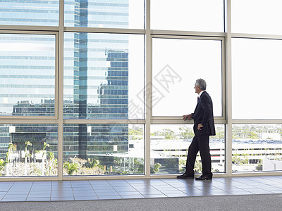 整个中年商务人士在办公室窗外看望的全中年商务人士图片
