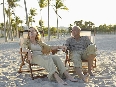 在热带海滩的甲板椅上放松 整个快乐的老年情侣婴儿关爱躺椅女性男士天空退休男人闲暇娱乐图片