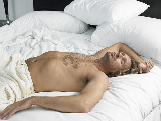 睡在旅馆卧室的英俊年轻男子图片