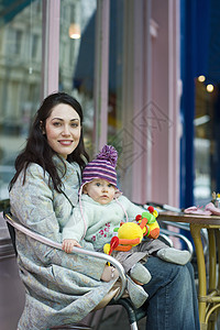 快乐的年轻母亲在咖啡厅坐在大腿上抱着婴儿的肖像女性女孩家庭孩子女儿桌子幸福关爱女士闲暇图片