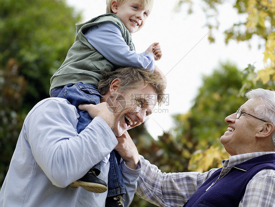 年轻男孩与父亲和祖父 在公园里玩得开心乐趣喜悦孩子们男人祖父母团结肩膀男士孩子儿子图片