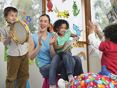 带儿童在课堂上玩音乐的幼儿教师图片