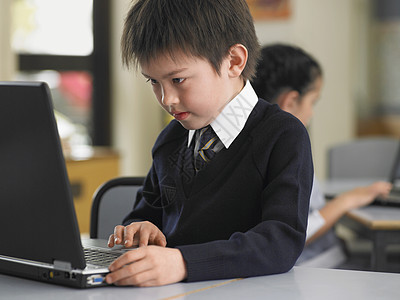 年轻男学生在桌桌上用笔记本电脑与前台女孩使用图片