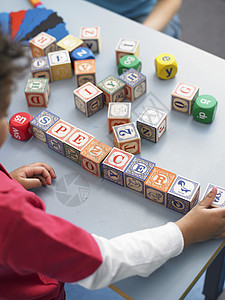 小男孩在课堂上玩字母块的游戏图片