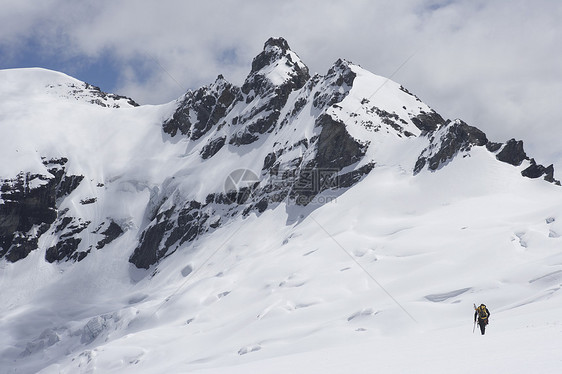 向雪中遥远的山峰方向行驶的徒步登山者的近视图片