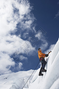 一名男性登山者的低角度视图 他们向雪坡上爬去 用斧子挡云远足者运动假期风雨飘摇探索者闲暇男人高度娱乐冒险图片