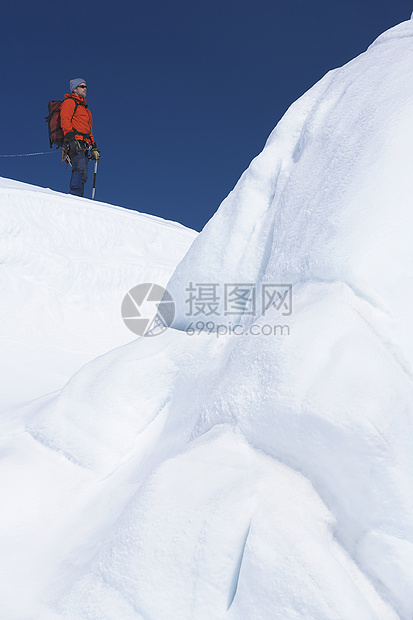 男子登山者站在雪山的冰层上站立图片