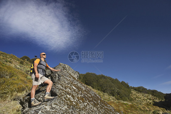 人类在森林山谷攀爬巨石图片