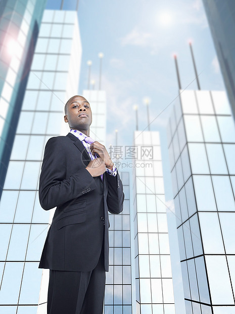 男性企业家在办公大楼前有自信的男性企业家调整领带图片