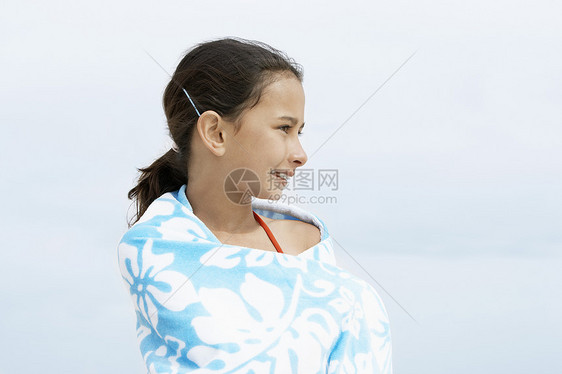 快乐的小少女 裹着毛巾的美少女 一边站在沙滩边 一边往远处看图片