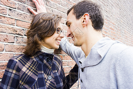 情侣在墙壁背景下看起来快乐的一对情侣微笑女孩女性闲暇眼镜季节家庭夫妻男人男性图片