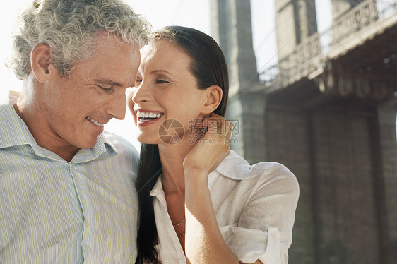 白种夫妇在背景中笑着带着桥图片