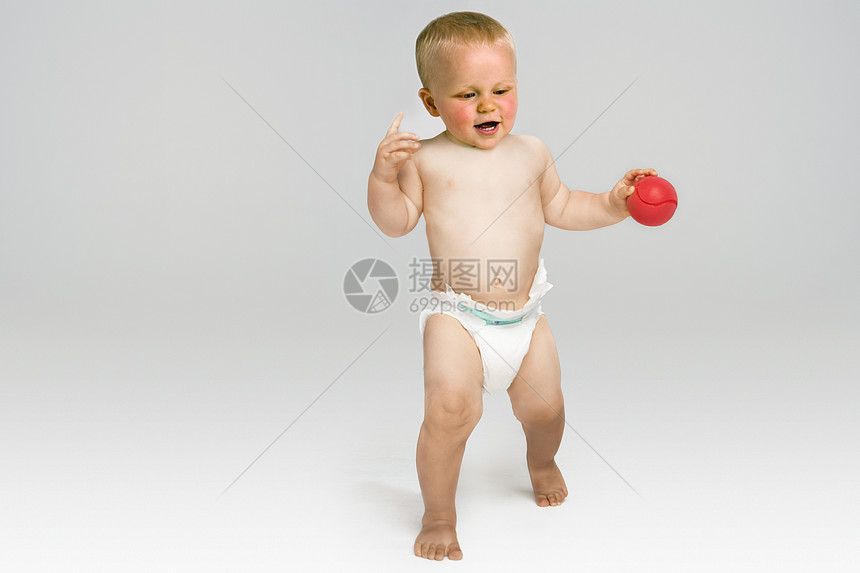 满身红球的男孩婴儿在灰色背景上被孤立图片