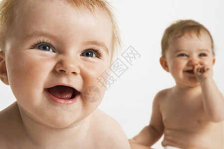 在白色背景中 微笑着的可爱婴儿的近身图片