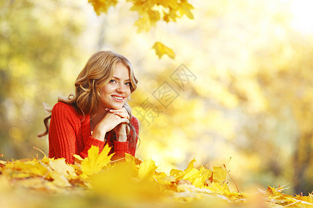 女人躺在秋叶上女孩金发乐趣快乐公园幸福女性橙子叶子红色图片