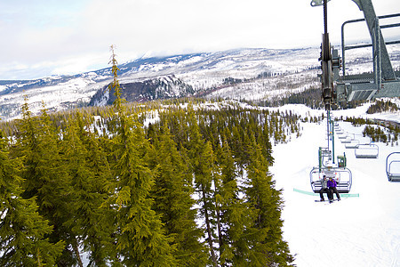 搭乘滑雪电梯的一对夫妇运动缆车女士滑雪板白色单板滑雪者夫妻旅行女孩图片