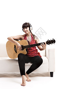 弹吉他长椅女孩微笑房子白色耳机客厅女性闲暇乐器图片