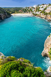 巴利阿里奇的莫诺卡美沙滩海滩海岸天空树木太阳波浪海岸线岩石石头海洋图片