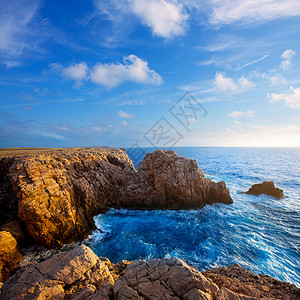 水溪巴利阿里群岛的日落石头海滩地标天空蓝色海岸支撑旅行海景海岸线背景