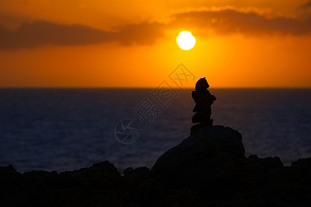 地中海日落时许愿的堆积石石头反射编队海洋旅行海岸太阳天空支撑海景图片