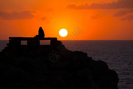 与女孩在Punta Nati日落晴天旅行天空蓝色海滩海洋海景支撑橙子太阳图片