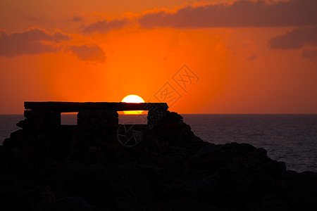 在Punta Nati 橙色日落天空地标天堂假期海景戏剧性海滩太阳海岸支撑图片