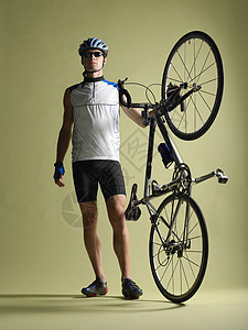 骑自行车者站着持自行车在车尾图片