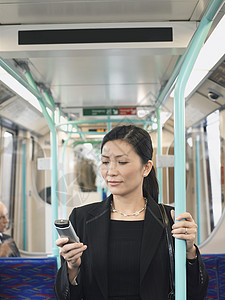 在火车上使用手机的亚洲青年商业女青年图片