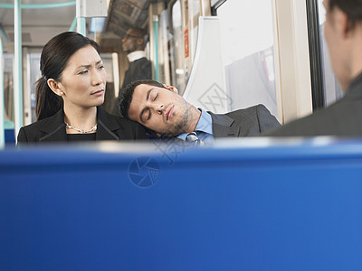 年轻人睡在火车上女商务人士的肩膀上图片