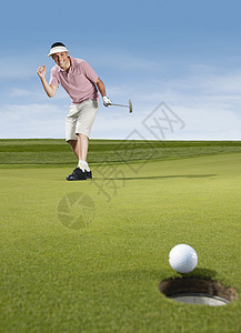 年青男性高尔夫球员在打高尔夫球时欢呼图片