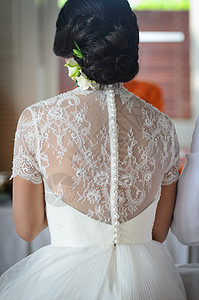 结婚那天年轻新娘的后背庆典生活丝带裙子兰花派对织物珍珠菊花会议图片