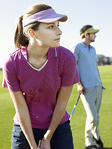 年轻妇女在高尔夫球场与男性朋友打高尔夫成人女性竞争者男士挑战课程女士马尾辫推杆运动服图片