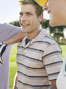 英俊的年轻男性高尔夫球手和高尔夫球场的朋友图片