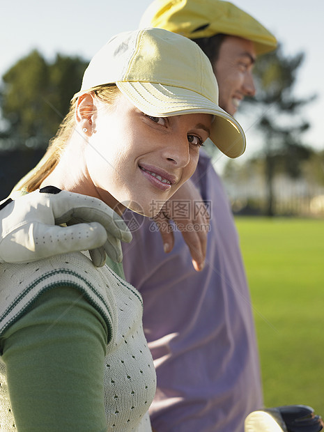 快乐的年轻女性高尔夫球手和高尔夫球场朋友的肖像图片
