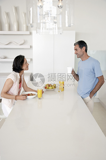 一对夫妇在厨房吃早餐的侧面视图图片
